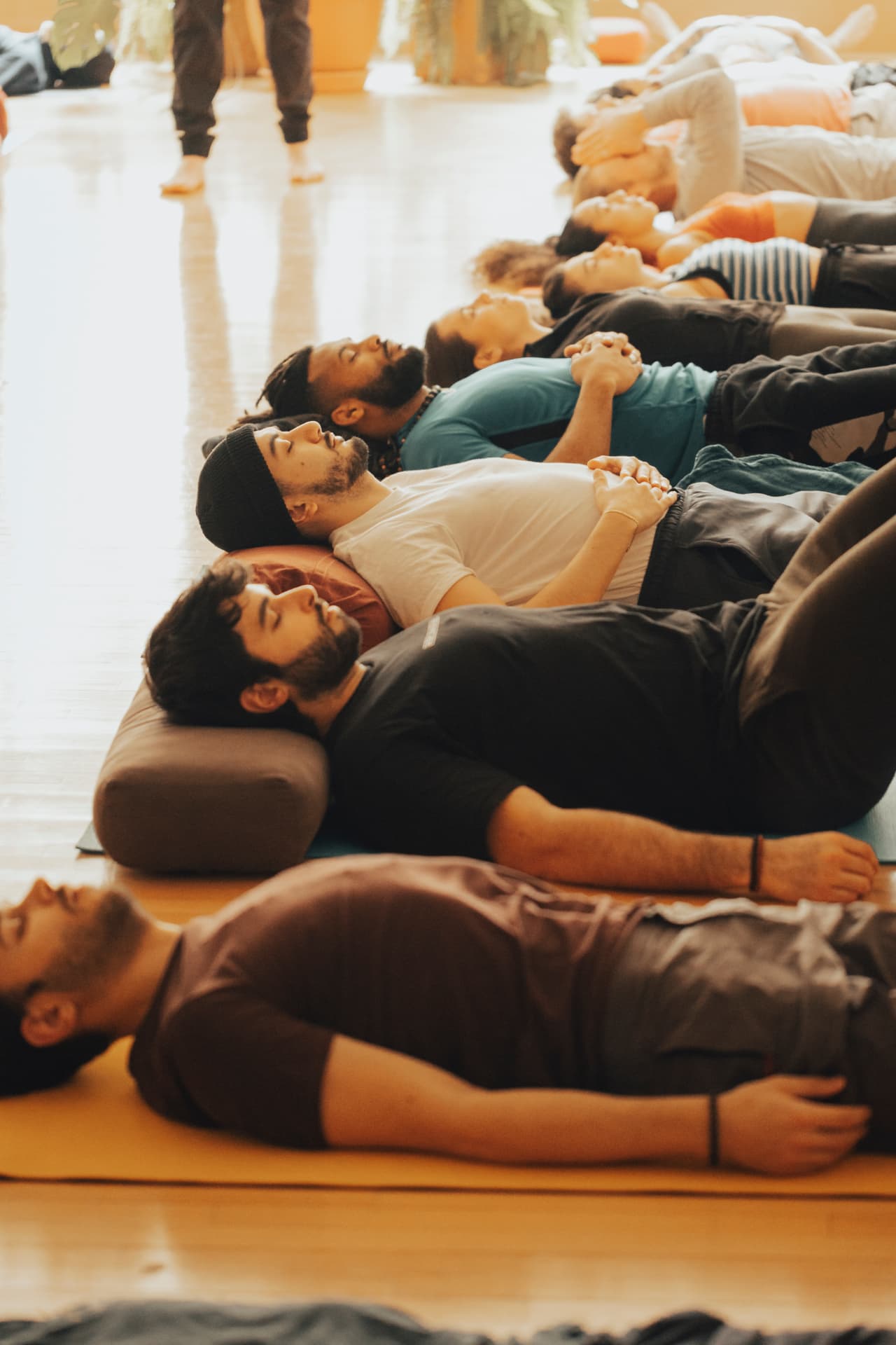 A row of participants resting in stillness after a breathwork round